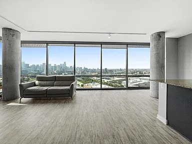 living area featuring a city view, expansive windows, and wood finished floors