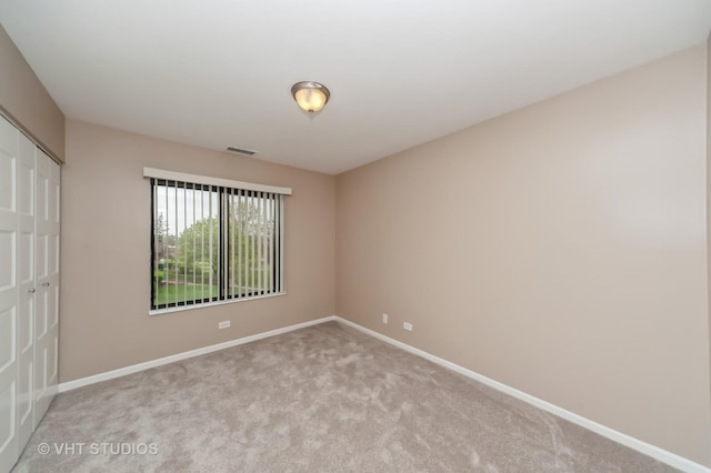 unfurnished bedroom with carpet flooring, baseboards, visible vents, and a closet