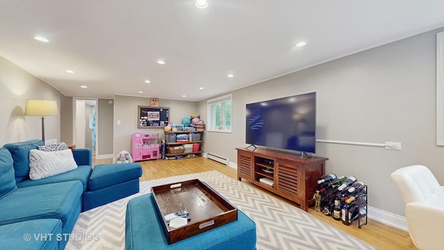 living area with recessed lighting, baseboards, baseboard heating, and light wood-type flooring