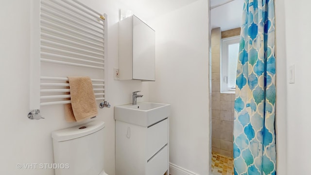 full bathroom with vanity, radiator, a tile shower, and toilet