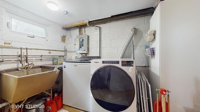 washroom with washing machine and clothes dryer, a sink, and electric panel