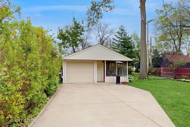 detached garage featuring fence and concrete driveway