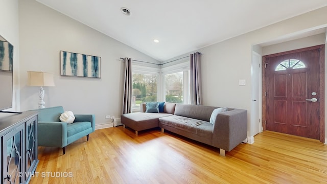 living room with light wood-style floors, baseboards, lofted ceiling, and visible vents