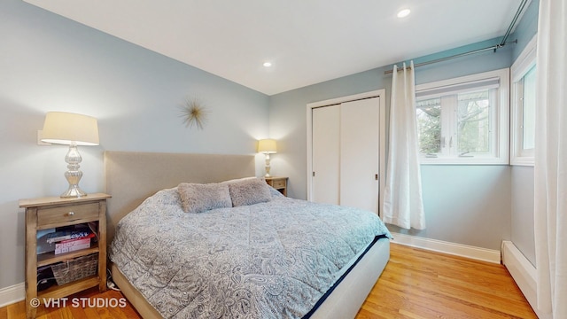 bedroom featuring baseboards, a closet, recessed lighting, and wood finished floors