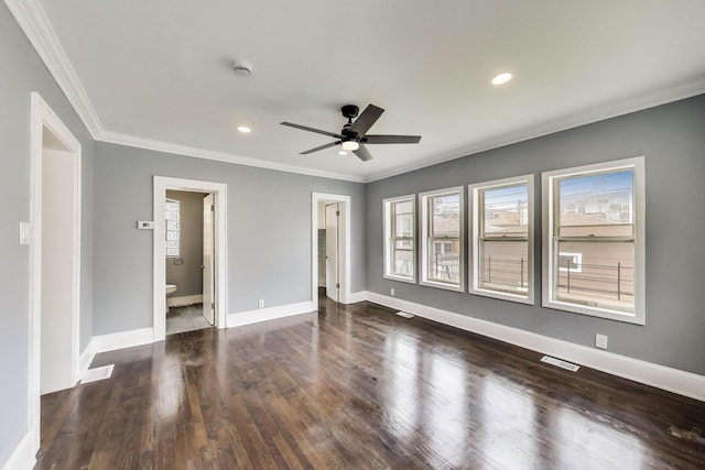 unfurnished bedroom with crown molding, multiple windows, wood finished floors, ensuite bathroom, and baseboards