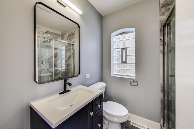 full bathroom featuring a shower stall, toilet, and vanity