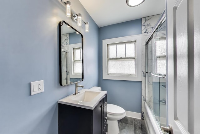 bathroom featuring baseboards, vanity, toilet, and shower / bath combination with glass door