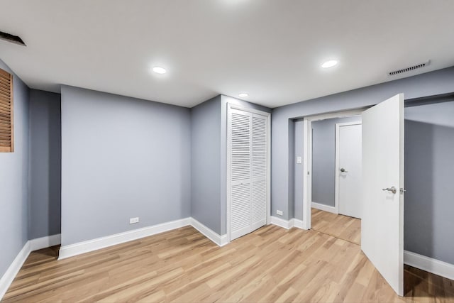 finished below grade area with light wood finished floors, baseboards, and recessed lighting