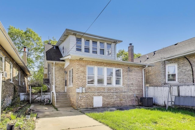 back of property with brick siding, fence, central AC unit, and a chimney