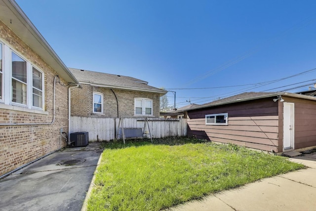 view of side of property featuring brick siding, cooling unit, and a patio