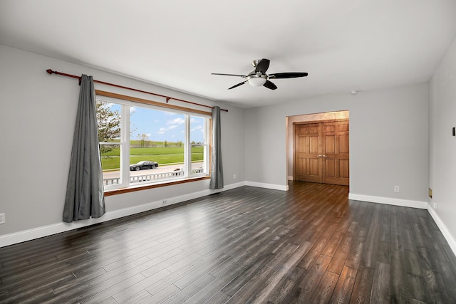 unfurnished bedroom with baseboards, a ceiling fan, and dark wood finished floors