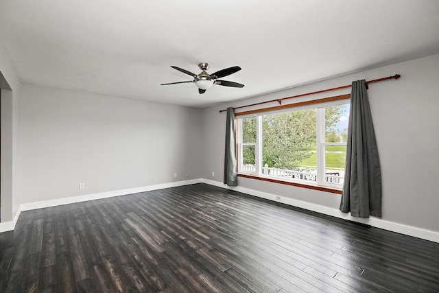 empty room with baseboards, dark wood-type flooring, and ceiling fan