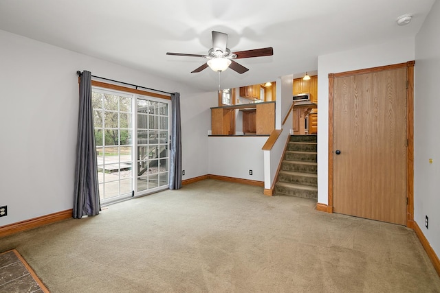 unfurnished living room featuring baseboards and light carpet