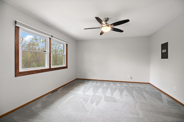carpeted spare room featuring baseboards, ceiling fan, and visible vents