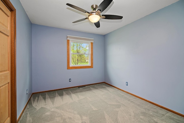 unfurnished room with a ceiling fan, baseboards, and light colored carpet