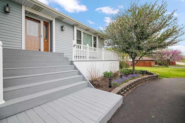 entrance to property featuring a lawn