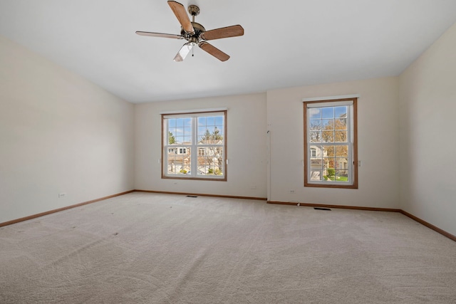 spare room with carpet flooring, baseboards, and ceiling fan