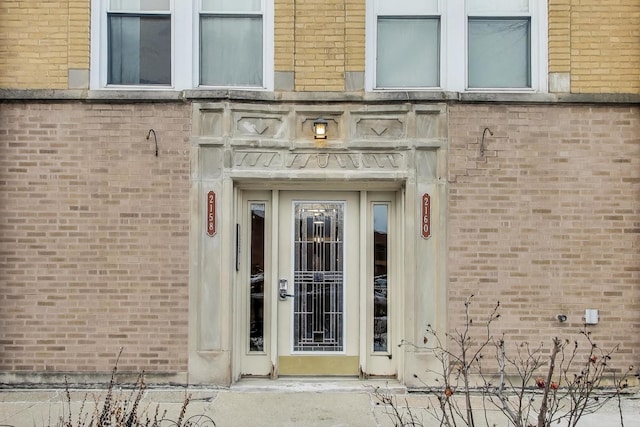 doorway to property featuring brick siding