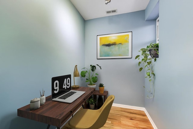 office area with visible vents, wood finished floors, and baseboards