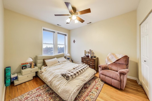 bedroom with a ceiling fan, visible vents, and light wood-type flooring