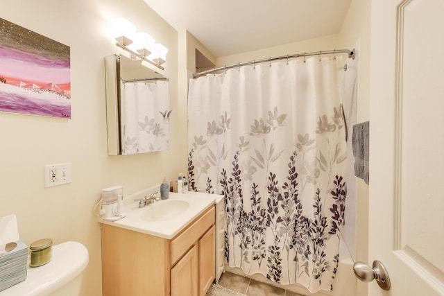 bathroom featuring toilet, curtained shower, tile patterned floors, and vanity