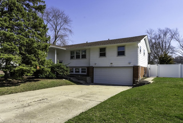 view of front of property with fence, a front yard, brick siding, concrete driveway, and an attached garage