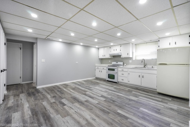 kitchen with a sink, light countertops, under cabinet range hood, white appliances, and white cabinetry