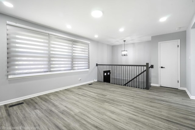 empty room with visible vents, recessed lighting, baseboards, and wood finished floors
