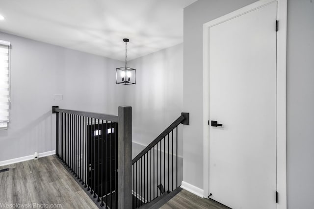 staircase with baseboards, visible vents, and wood finished floors