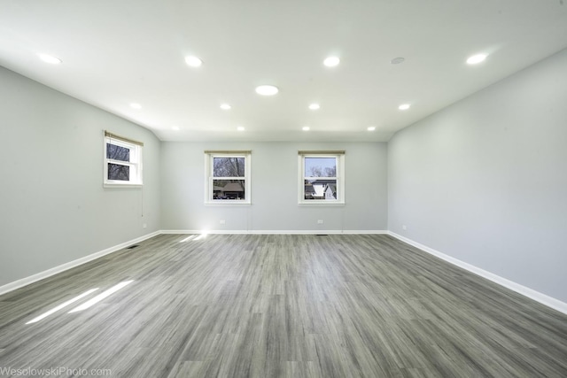 unfurnished living room featuring baseboards, recessed lighting, and wood finished floors