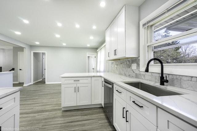 kitchen with a peninsula, recessed lighting, white cabinets, a sink, and dishwasher