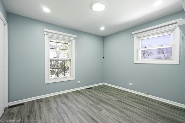 unfurnished room with baseboards, recessed lighting, wood finished floors, and visible vents