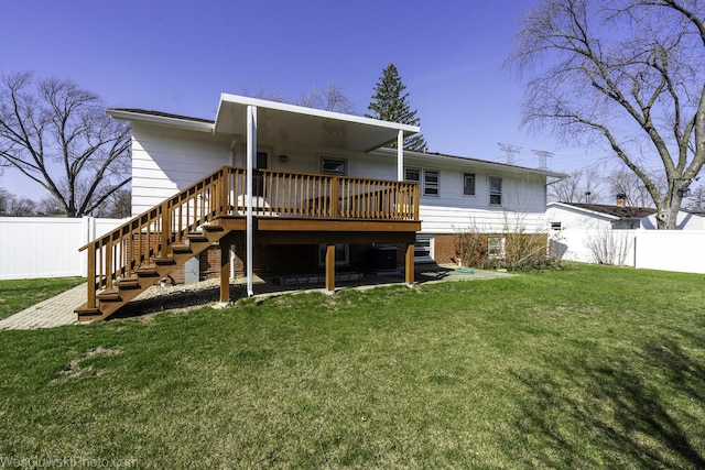 back of house featuring stairway, a lawn, a wooden deck, and a fenced backyard
