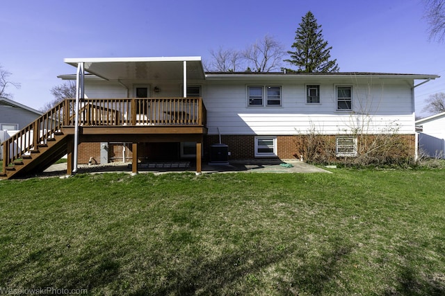 back of property featuring a wooden deck, stairs, central AC unit, brick siding, and a lawn