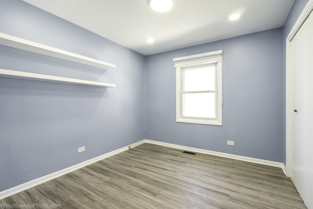 spare room featuring baseboards, recessed lighting, wood finished floors, and visible vents