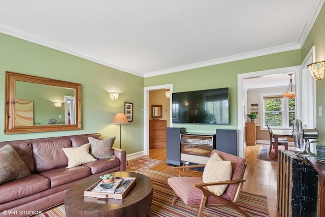 living room featuring crown molding, wood finished floors, and baseboards