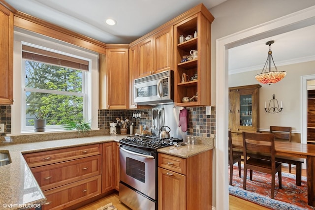 kitchen featuring appliances with stainless steel finishes, tasteful backsplash, crown molding, light wood-style flooring, and light stone countertops