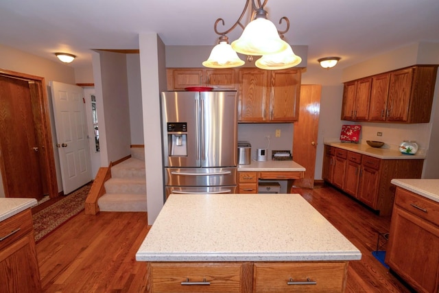 600 Salceda Dr, Mundelein, IL 60060 - kitchen featuring stainless steel fridge with ice dispenser, brown cabinetry, dark wood-type flooring, light countertops, and pendant lighting