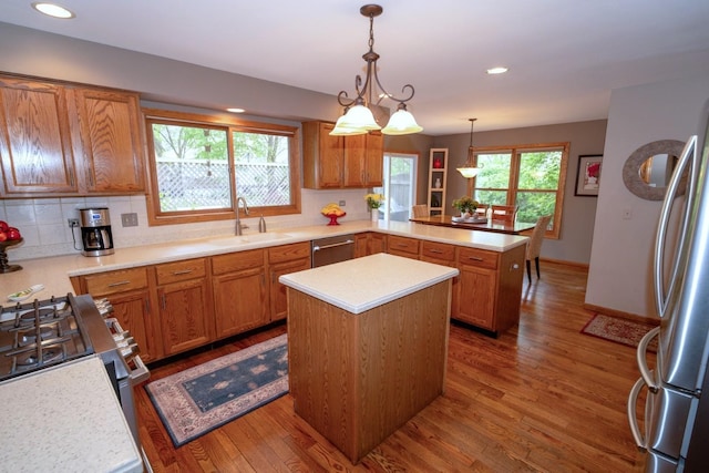 600 Salceda Dr, Mundelein, IL 60060 - kitchen featuring a sink, a peninsula, light countertops, stainless steel appliances, and wood finished floors