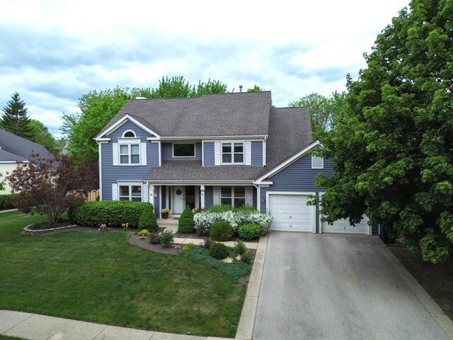 600 Salceda Dr, Mundelein, IL 60060 - traditional-style home featuring driveway, a front lawn, a garage, a shingled roof, and a porch