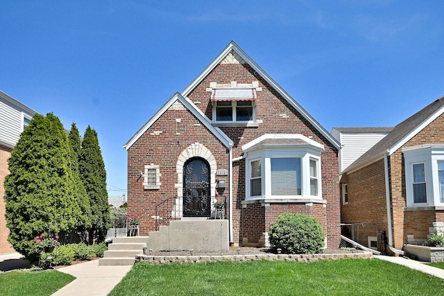 tudor home featuring brick siding