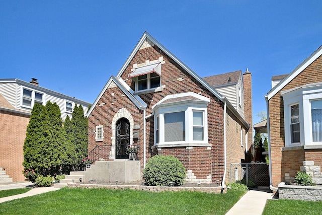 tudor home featuring brick siding
