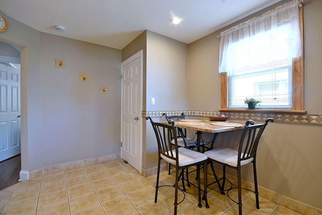 dining room with baseboards and light tile patterned floors