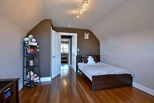 bedroom with dark wood finished floors, vaulted ceiling, and baseboards