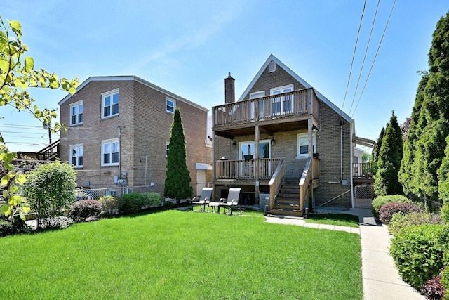 back of property featuring a yard, brick siding, a deck, a chimney, and a balcony