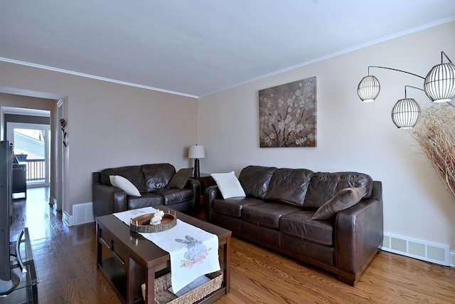 living area featuring ornamental molding, wood finished floors, and baseboards