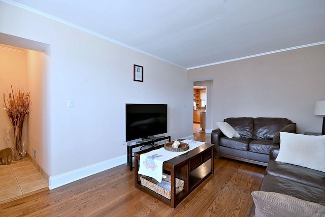 living room with ornamental molding, wood finished floors, and baseboards