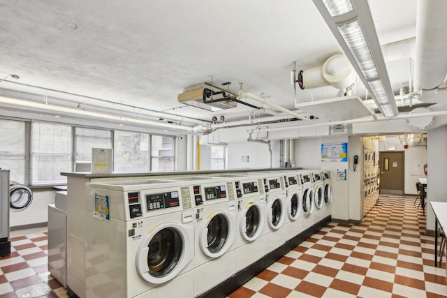 community laundry room featuring tile patterned floors, baseboards, and independent washer and dryer