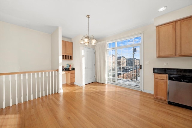 unfurnished dining area with light wood finished floors, recessed lighting, a notable chandelier, and baseboards