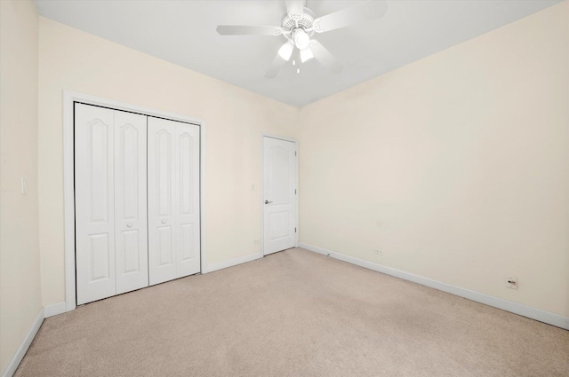 unfurnished bedroom featuring baseboards, a ceiling fan, a closet, and carpet